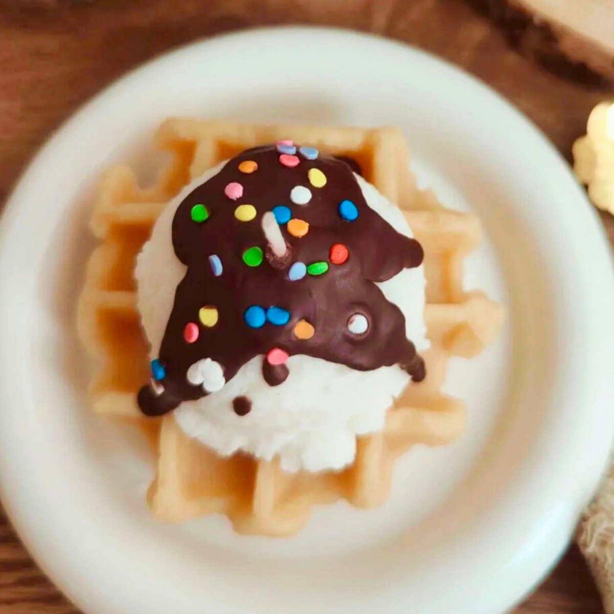Round waffle scented candle with vanilla cream, chocolate sauce and rainbow sprinkles