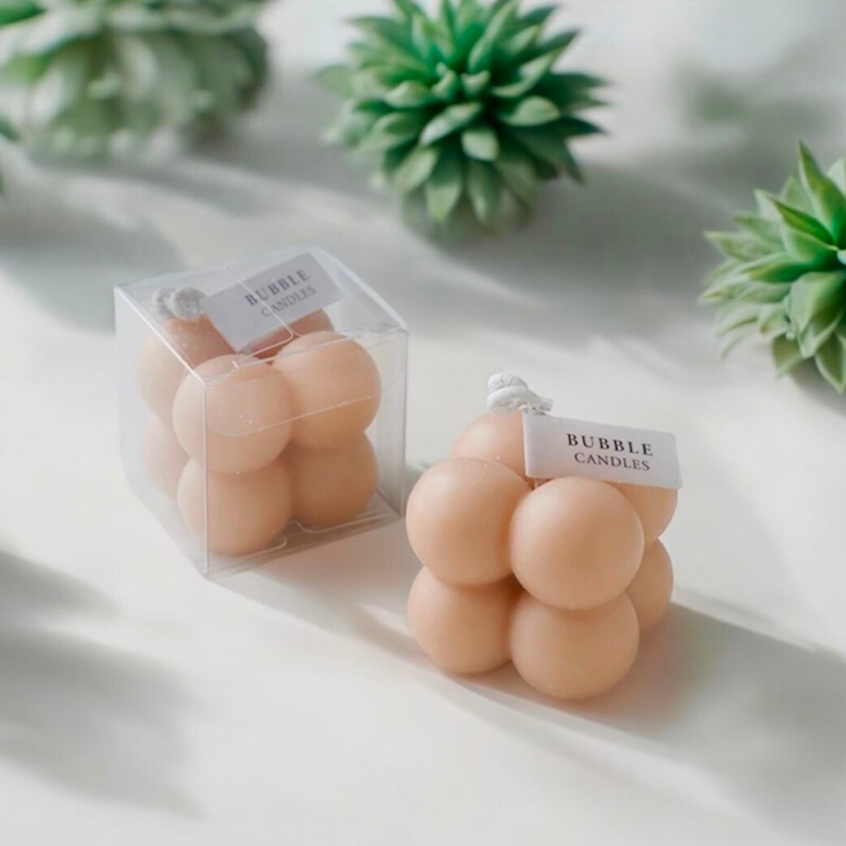 Peach skin beige bubble cube scented candle with its clear gift box and succulents