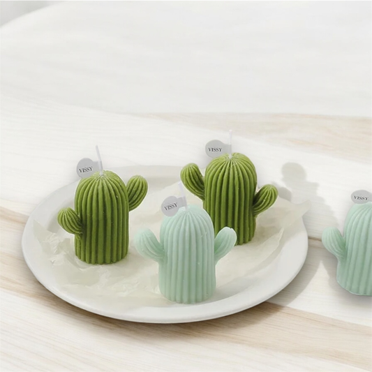 Olive green and mint cactus shaped scented candles on a white plate