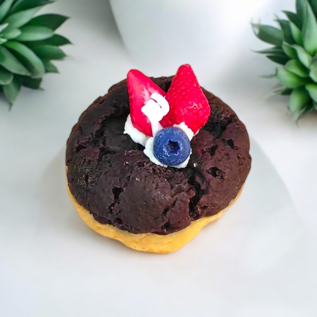 Chocolate cookie scented candle topped with strawberries and a blueberry