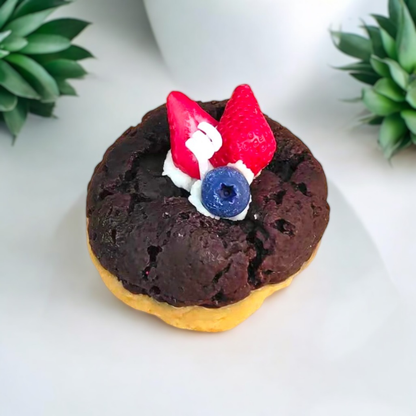Chocolate cookie scented candle topped with strawberries and a blueberry