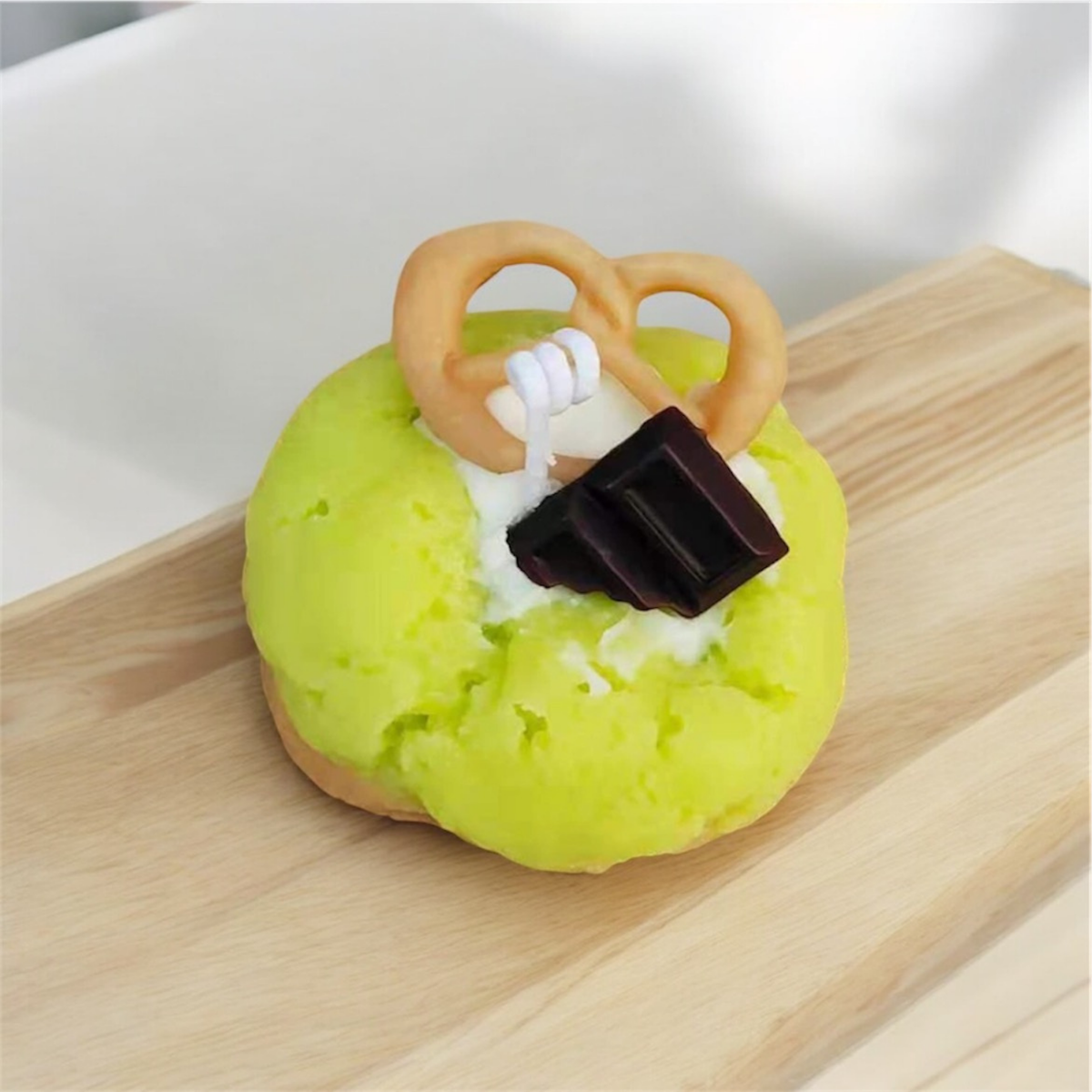 Green matcha cookie scented candle with a pretzel and chocolate square