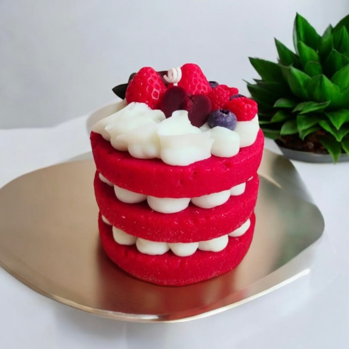 Red velvet three layer cake scented candle topped with strawberries and berries