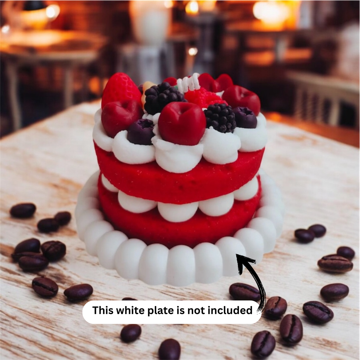 Red two layer berry cake scented candle on a wooden cafe table with coffee beans