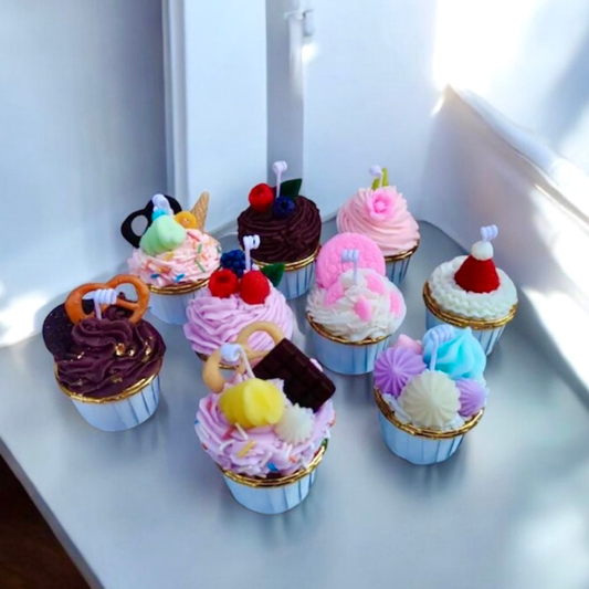 Eight assorted mini cupcake scented candles with colourful frosting on a windowsill