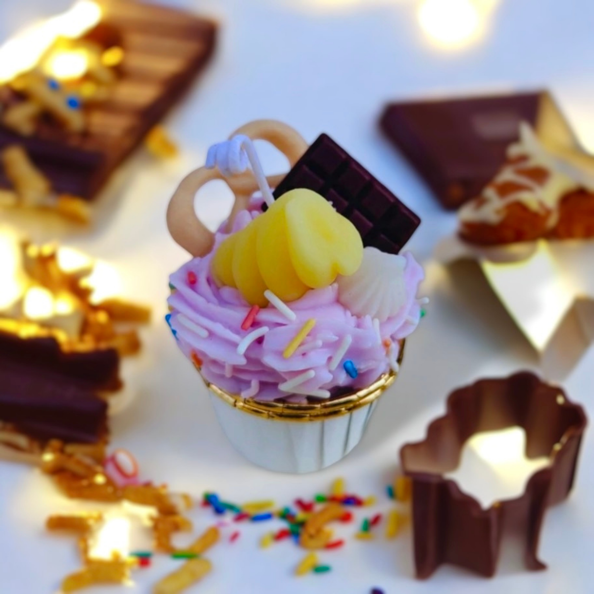 Pink cupcake scented candle with a chocolate bar, pretzel ring and banana swirl