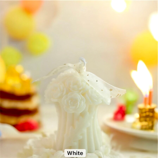 White rose bouquet scented candle with a ribbon bow on a party table