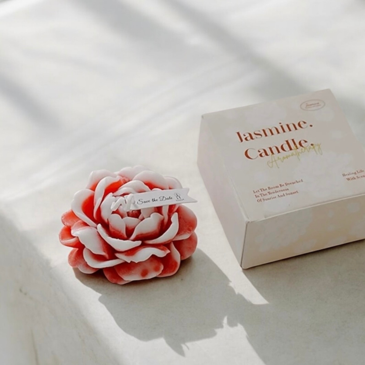Pink and white peony flower scented candle beside its Jasmine Candle gift box