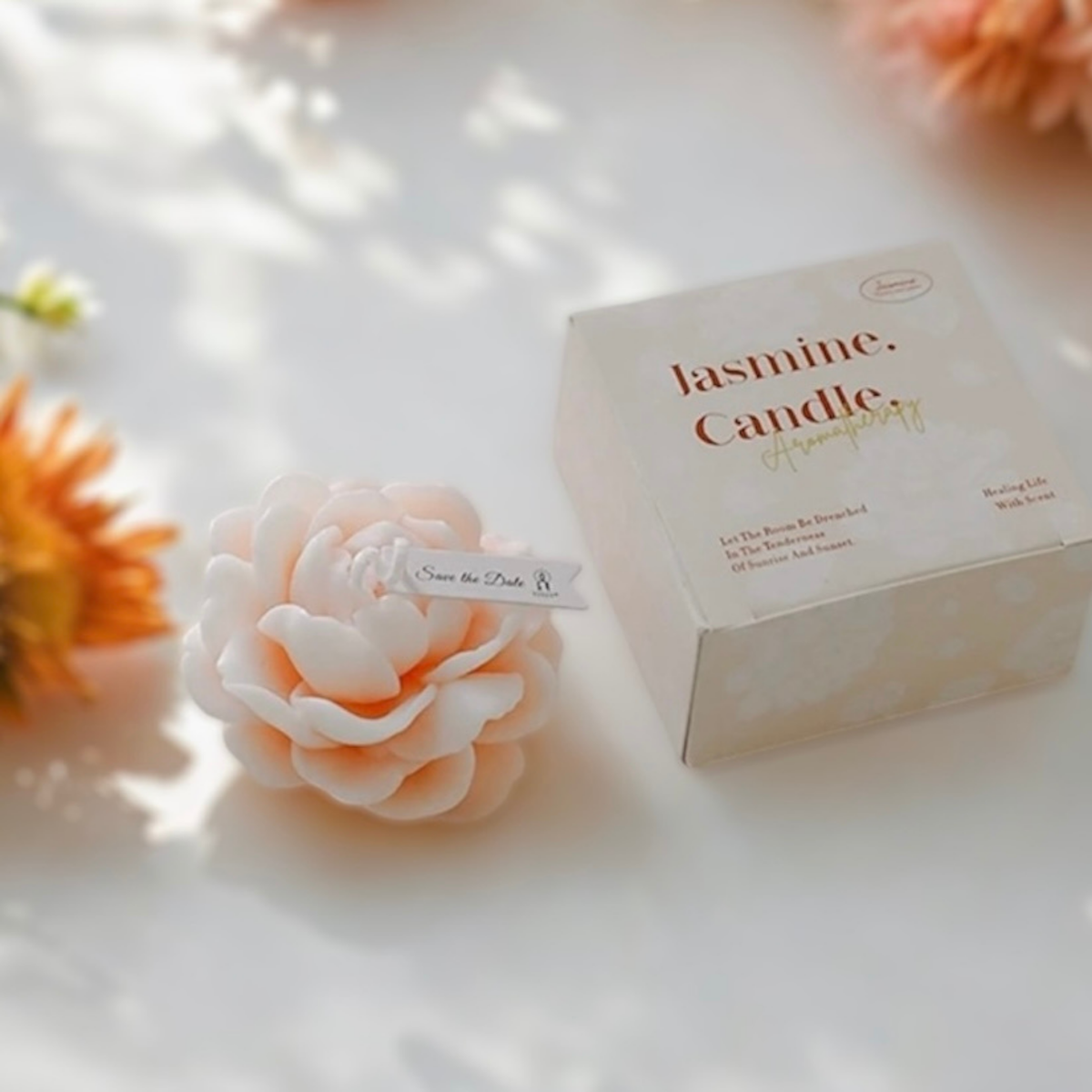 Pale peach peony flower scented candle beside its Jasmine Candle gift box