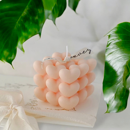 Tender pink heart cube scented candle resting on a handwritten gift note