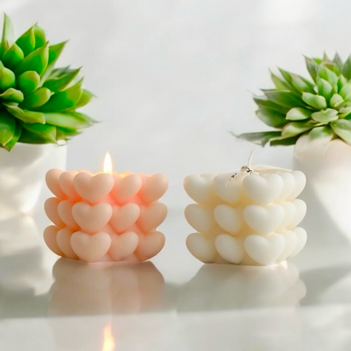 Peach and white heart cube scented candles side by side, one lit