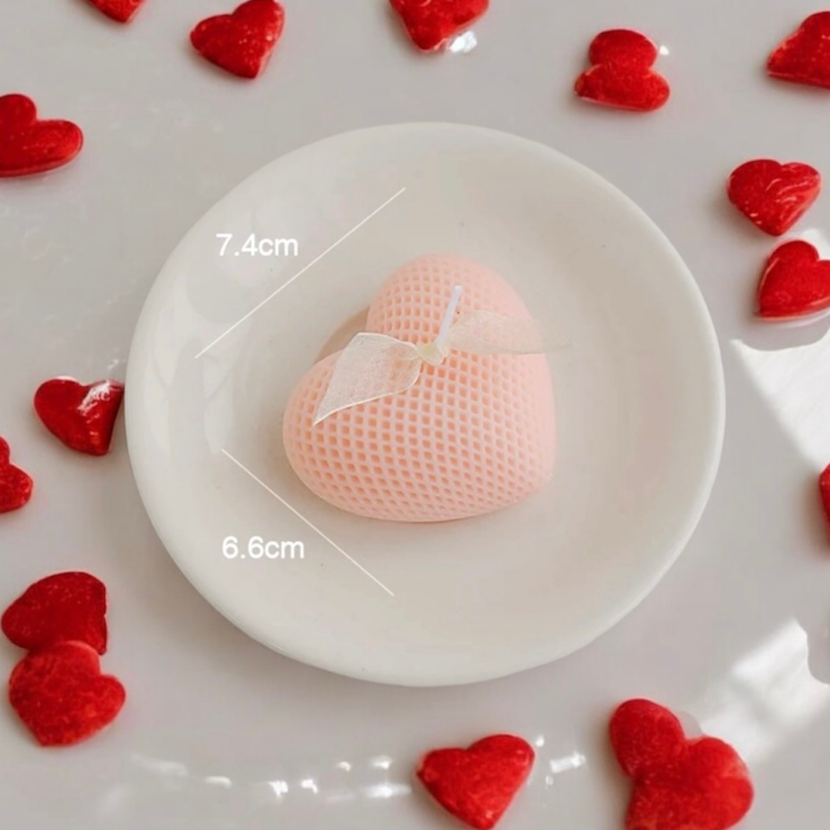Peach heart scented candle with a bow, surrounded by small red hearts