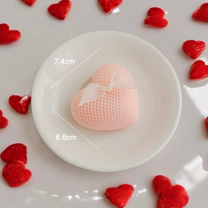 Peach heart scented candle with a bow, surrounded by small red hearts