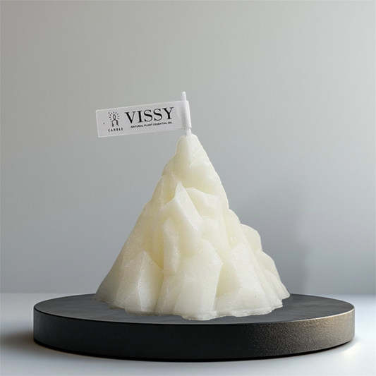 White mountain shaped scented candle on a black stand