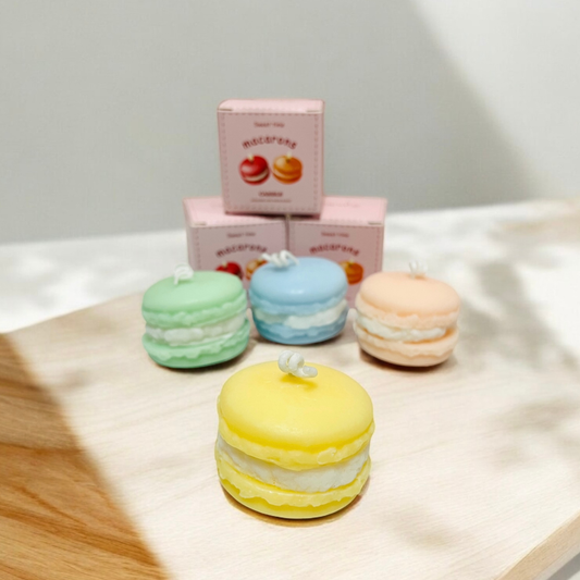 Yellow, green, peach and baby blue macaron scented candles on a wooden board
