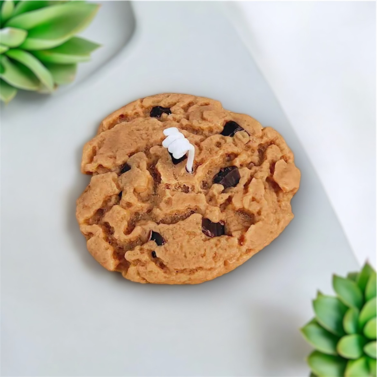 Tan chocolate chip cookie scented candle on a soft background