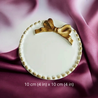 Ceramic candle plate with a gold bow and beaded rim, 10 cm by 10 cm