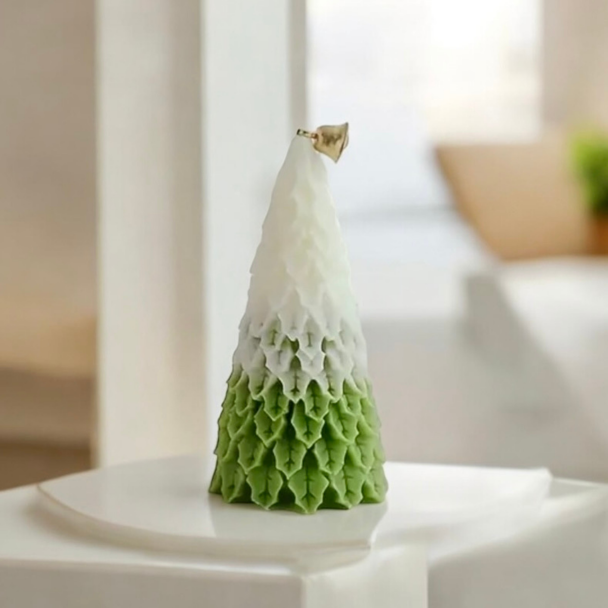 Light green ombre Christmas tree scented candle on a white table