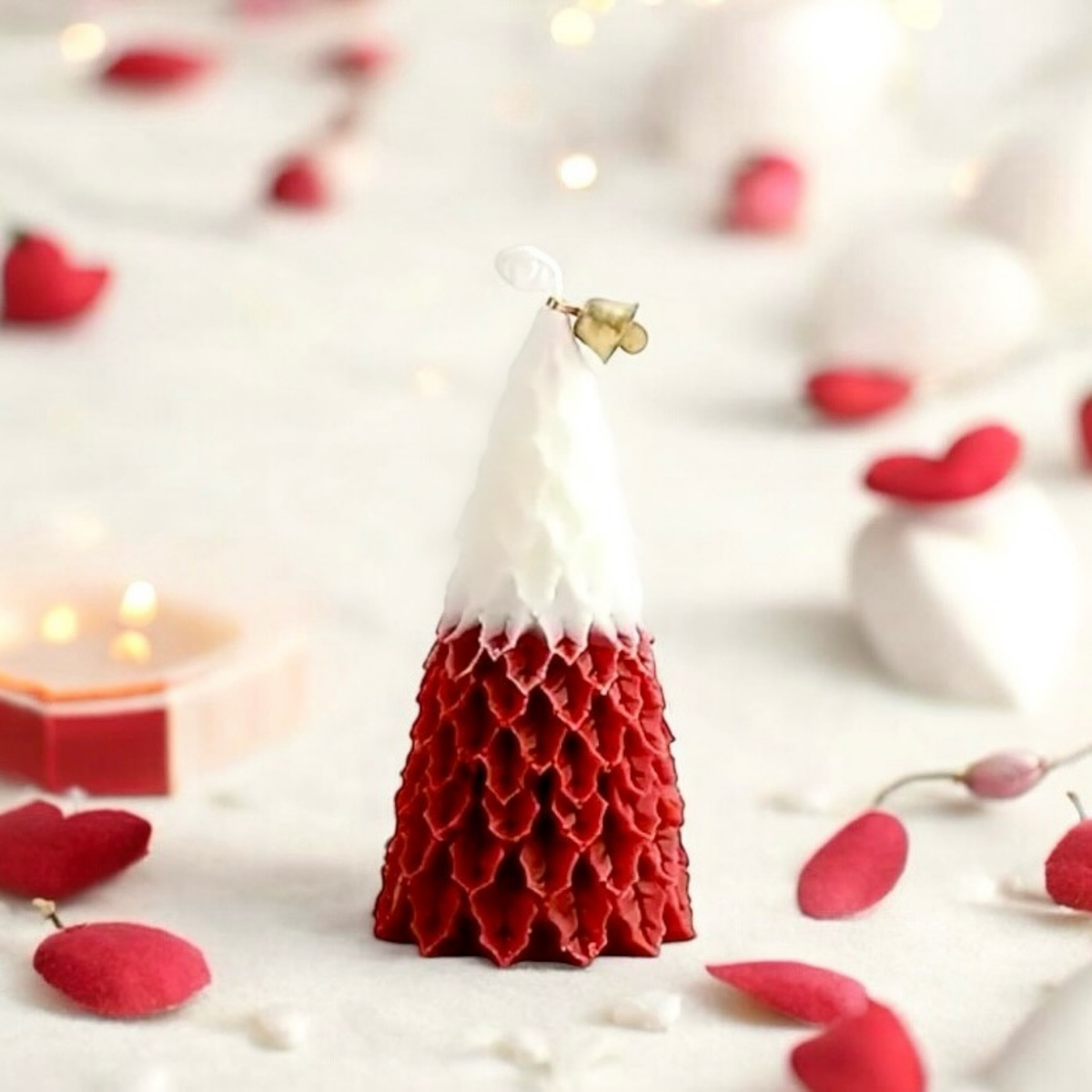 Red and white Christmas tree scented candle surrounded by red hearts